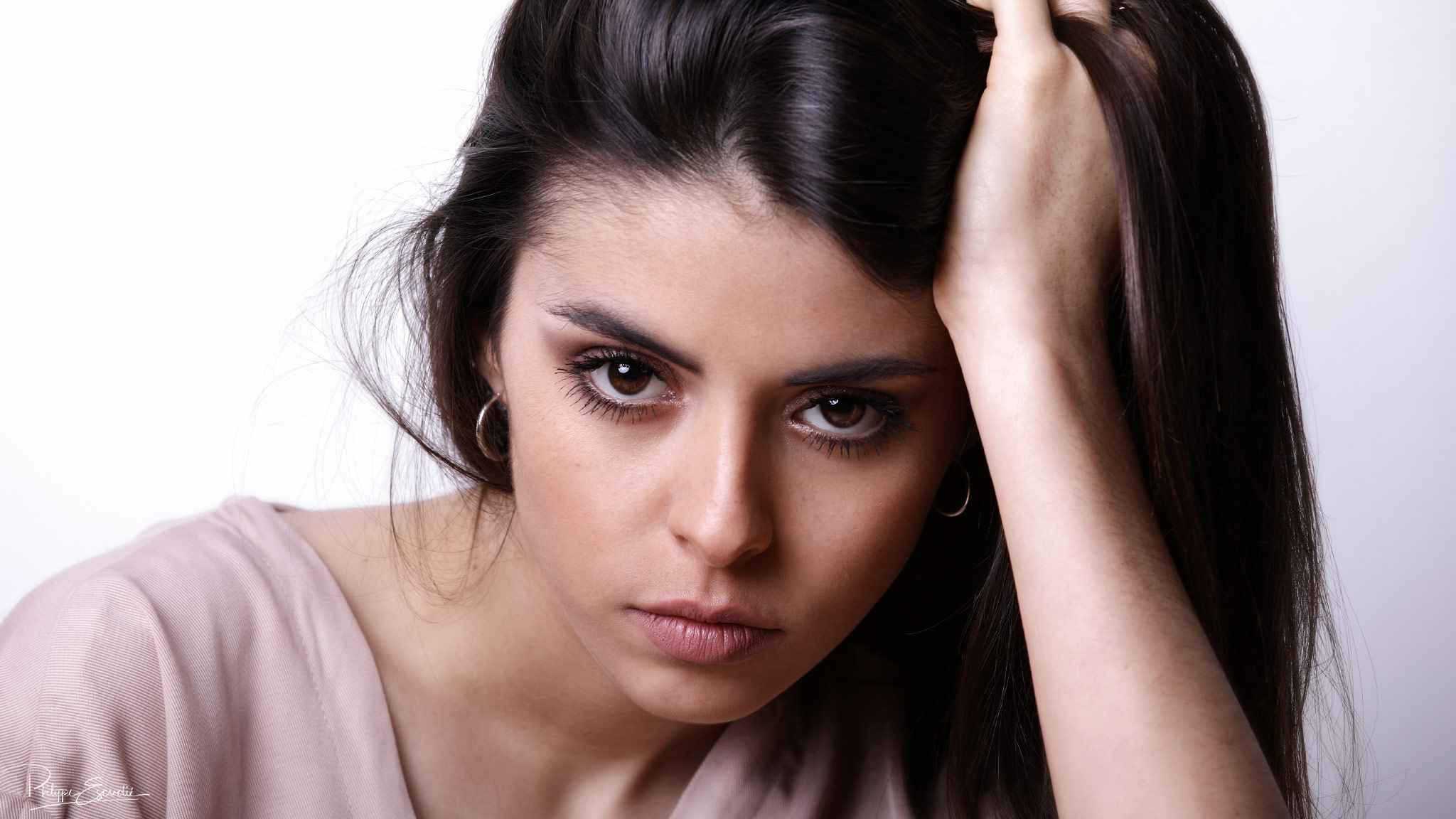 Portrait visage de Jennyfer, jeune modèle photo féminin, la main dans les cheveux.