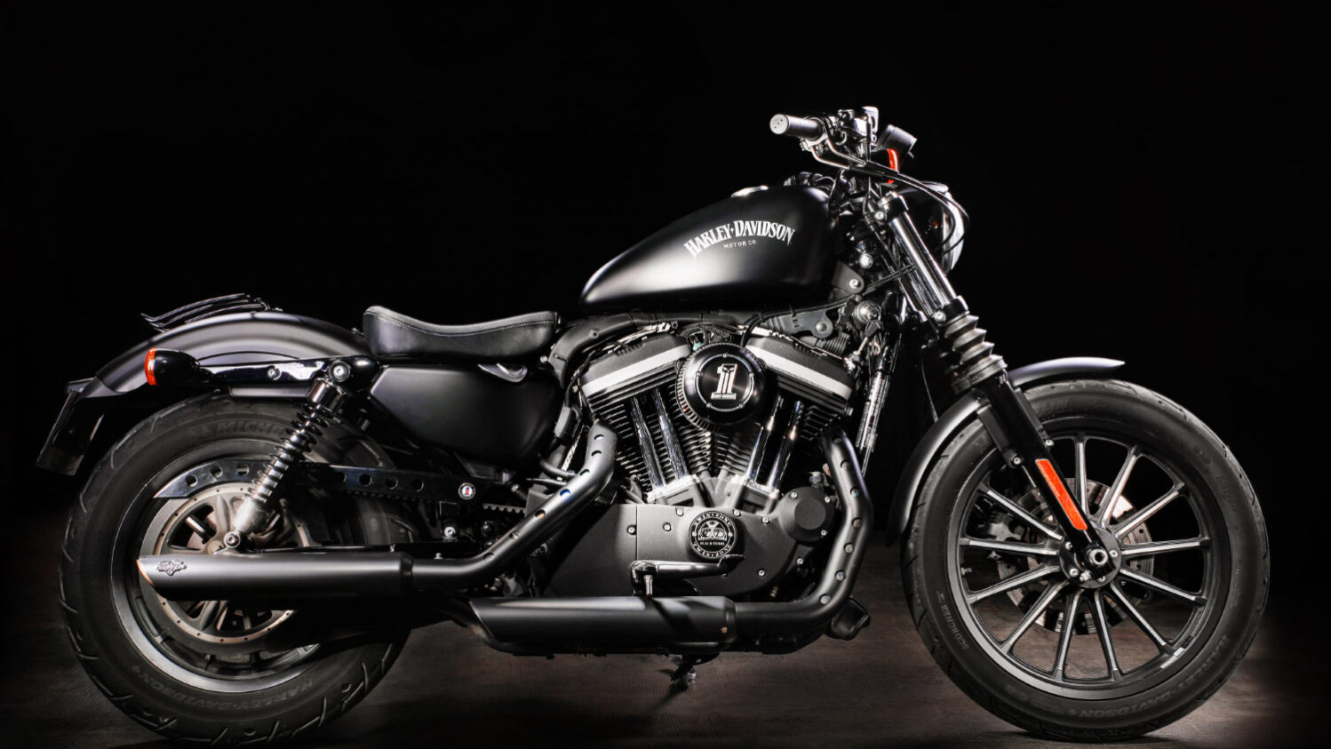 Une moto de marque Harley Davidson de profil sur fond noir