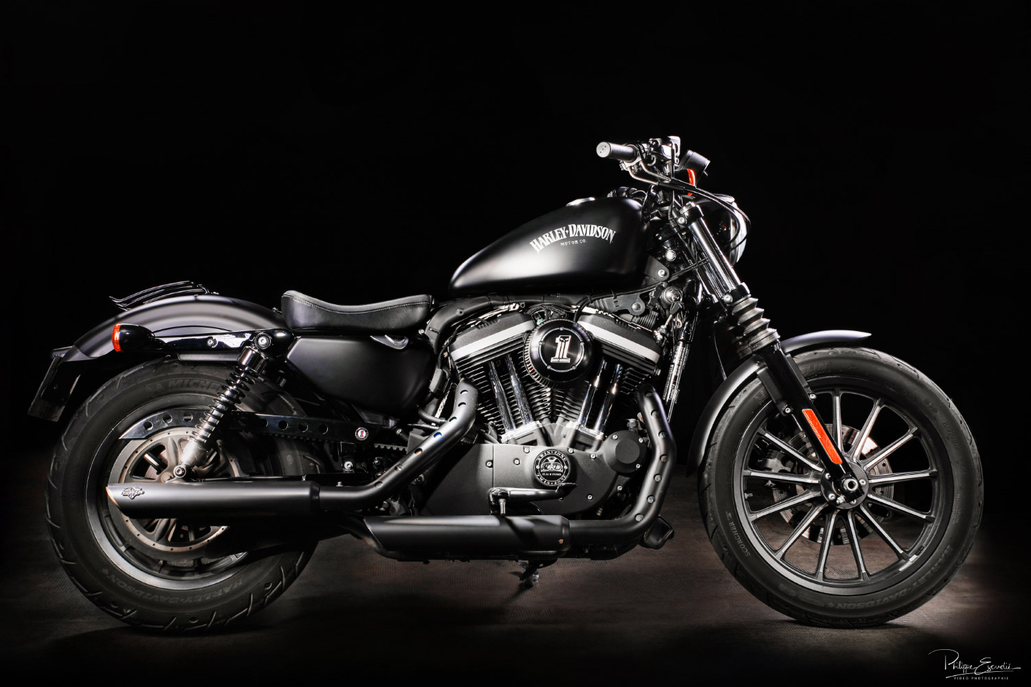 Une moto de marque Harley Davidson de profil sur fond noir